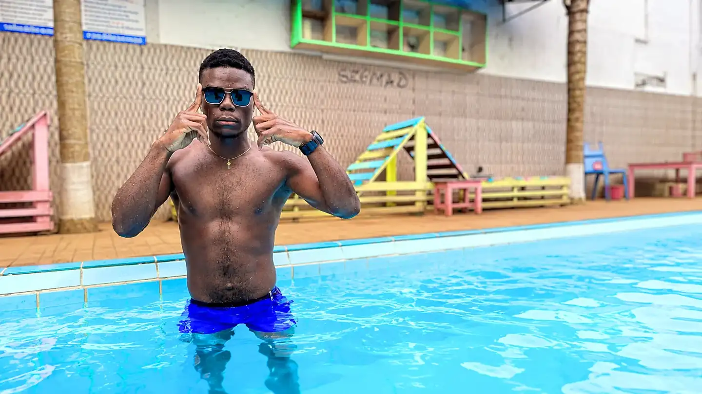 Coach Junior enseignant la technique de la brasse dans une piscine à Yaoundé Ngousso.